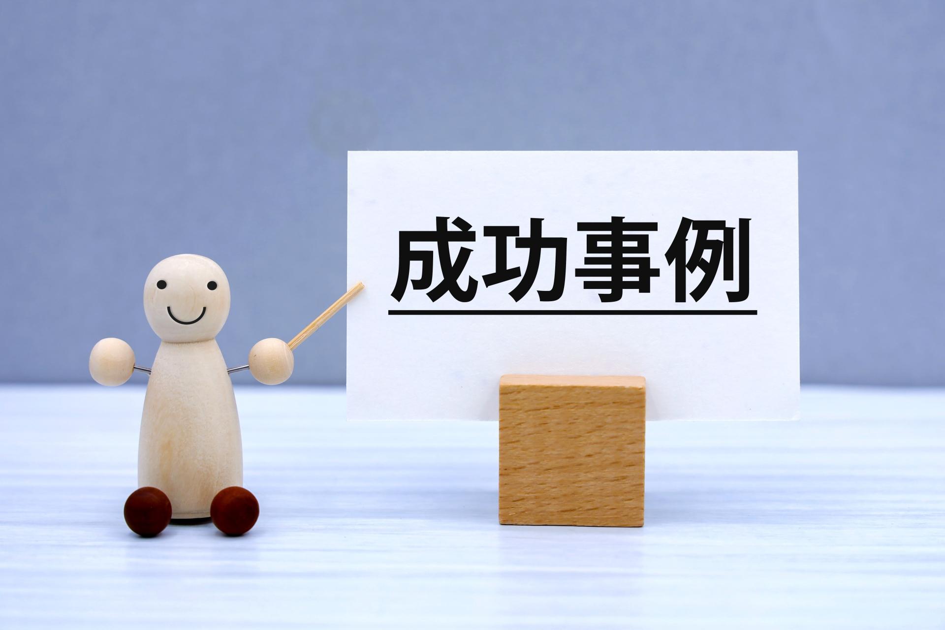 成功事例と書かれた札を指す人形