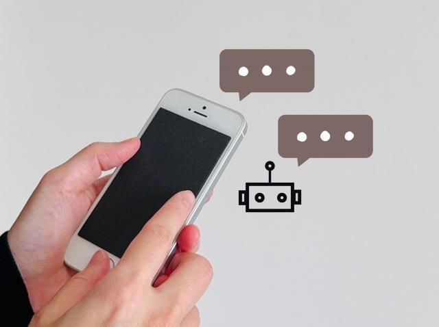 スマホを操作する手元とAIチャットボット